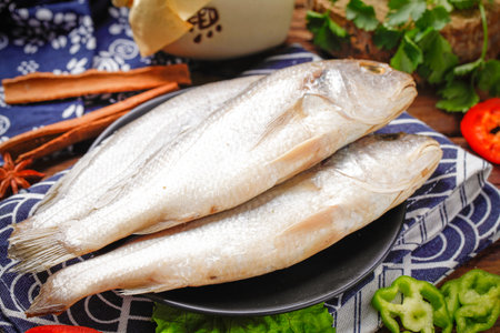 Fresh raw fish in a black plate on a blue tablecloth.の写真素材