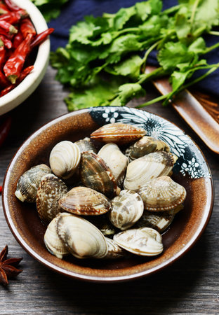 Steamed clams with chili pepper and coriander on wooden backgroundの写真素材