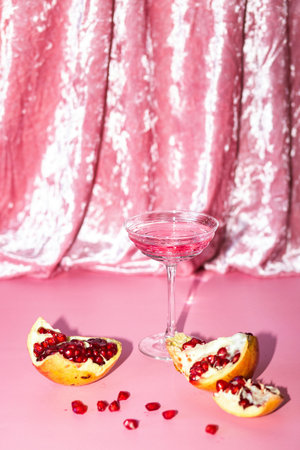 Glass of pomegranate juice and ripe fruits on pink backgroundの写真素材