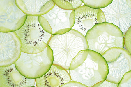 Slices of cucumber and kiwi on white backgroundの写真素材