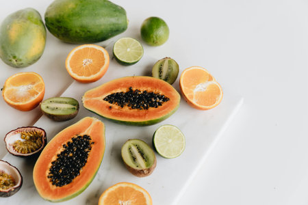 slices of orange, kiwi and papaya on white backgroundの写真素材