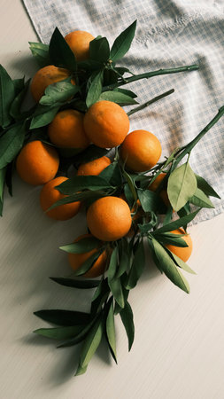Fresh tangerines with green leaves on a white wooden table. Toned.の写真素材