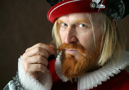 close-up portrait of a man of the Middle Ages with a beard and mustache in a suit isolated on a dark...