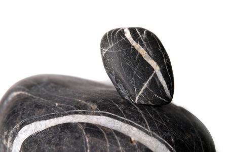 close-up of smooth black stones with white stripes isolated on white backgroundの写真素材