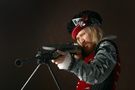 close-up portrait of a man of the Middle Ages with a beard and mustache in a suit isolated on a dark background with a weaponの写真素材