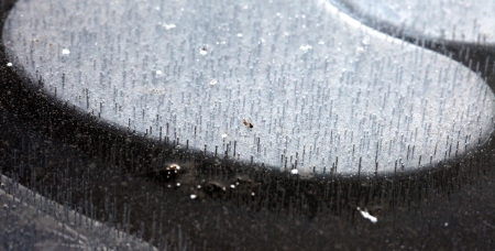macro texture of the frozen ice and bubbles on the river bizarre
