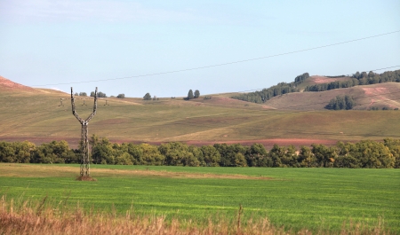 autumn landscape picturesque fields and meadows and power lines passing through themの写真素材