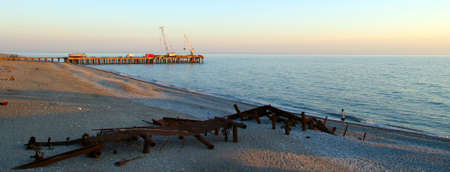 seascape sunset over the sea and two piers new and old ruinedの写真素材