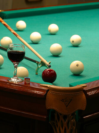 close-up of a billiard table with green cloth with balls and cue
