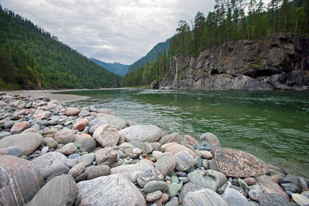 magnificent mountain landscape river, forest and cloudy sky in summerの写真素材