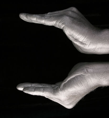 close-up of human hands represent a form of bowls or flower on black background, side view studioの写真素材