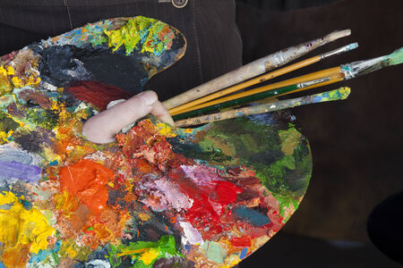 macro artist palette in hand, texture mixed oil paints in different colors and saturation studioの写真素材