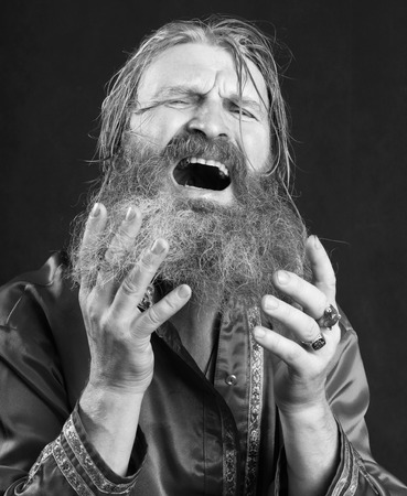 close-up portrait of the blessed with a long beard and a mustache and wet blond hair in a red shirt studioの写真素材