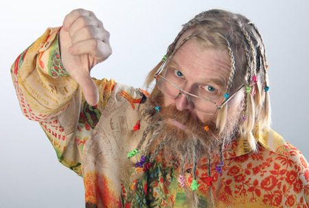 close-up portrait of an adult male with long beard, mustache and hair braided in pigtails gesturing...