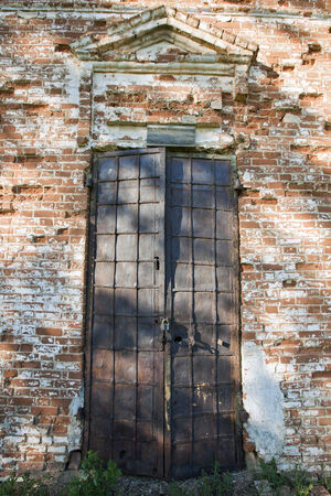 close-up closed doors old ruined church on a sunny spring dayの写真素材