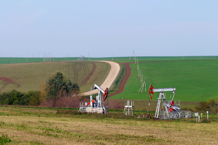 summer landscape oil pumps on the background fields and the road on a sunny day