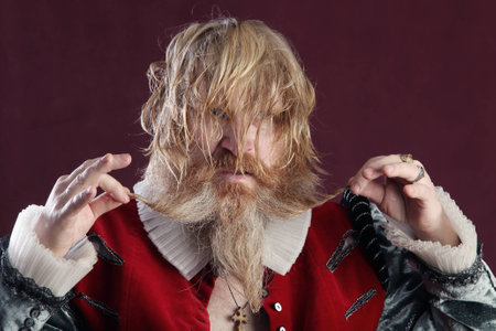 close-up portrait of an adult male with long blonde hair with a beard and mustache crazy kindの写真素材