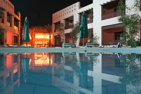 seaside resort hotel building and landscaped grounds with pool in summer nightのeditorial素材