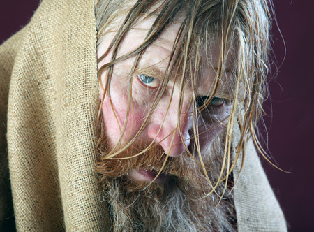 close-up portrait of the blessed with a long beard and a mustache and wet blond hair in a red shirt studioの写真素材