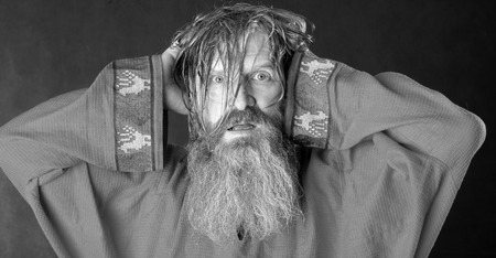 close-up portrait of the blessed with a long beard and a mustache and wet blond hair in a red shirt studioの写真素材