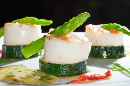 macro white dish with zucchini and asparagus beautifully decorated studio on dark の写真素材