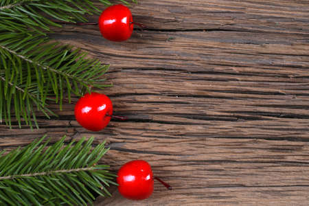 close-up still-life of fir branches and cherry on magic Christmas holiday on background a wooden boards studioの写真素材