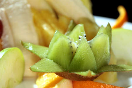 macro beautiful fruit salad on a white plate on a black background studioの写真素材