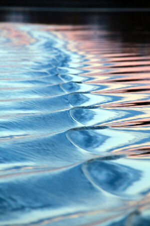 close-up amazing wavy trace of the boat on the river at sunsetの写真素材