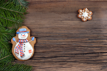 close-up still-life of fir branches and the gingerbread with pattern on  magic Christmas holiday on background a wooden boards studioの写真素材