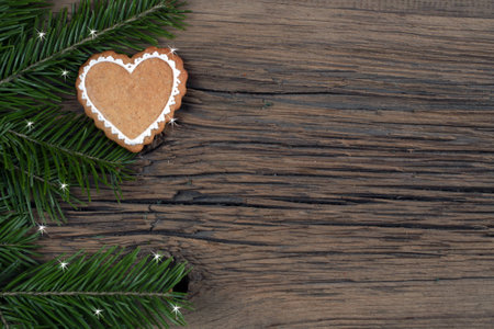 close-up still-life of fir branches and the gingerbread with pattern on magic Christmas holiday on background a wooden boards studioの写真素材