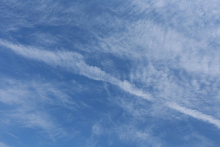 close-up whimsical cirrus clouds against blue sky