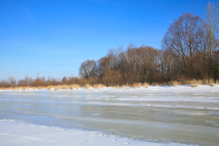 winter landscape backwater in the ice against the blue sky on a clear sunny dayの写真素材