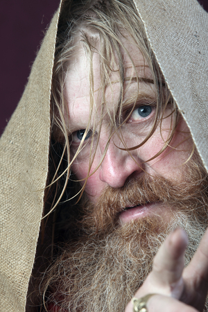 close-up portrait of the blessed with a long beard and a mustache and wet blond hair in a red shirt studioの写真素材
