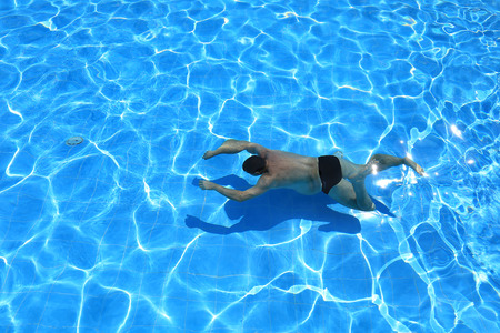 isolated azure water pool and swimmer in the waterの写真素材
