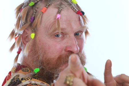 close-up portrait of a man with braids, mustache and beard in colored shirt on a white background...