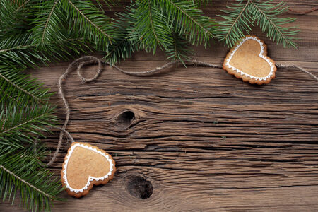 close-up of beautiful festive Christmas still life of the branches of spruce, cookies and spice on wood background with cracks studioの写真素材