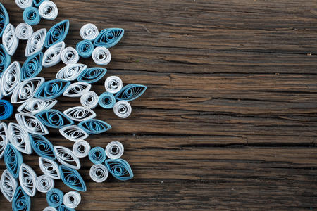 close-up of a snowflake out of paper quilling technique against the background of the old cracked boardの写真素材
