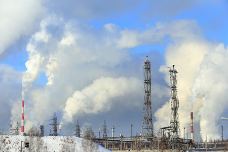 industrial landscape smoke from the chimneys large plant and power lines against the blue sky in...
