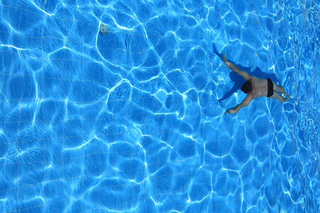 isolated azure water pool and swimmer in the water