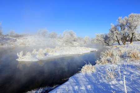 foggy winter landscape frosty morning over the river and trees in hoarfrost on the shores of