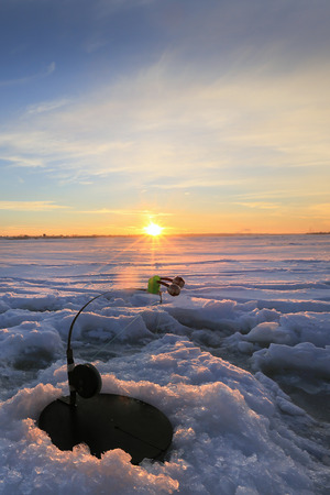 winter landscape the rod on the river near  hole at sunsetの写真素材