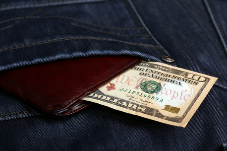 close-up of dollar bills pocket denim trousers, studio