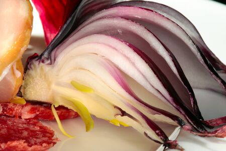close-up meats of different varieties decorated with greens and tomatoes on white dishの写真素材