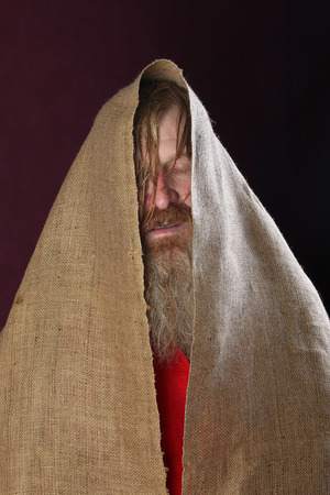 close-up portrait of the blessed with a long beard and a mustache and wet blond hair in a red shirt studioの写真素材