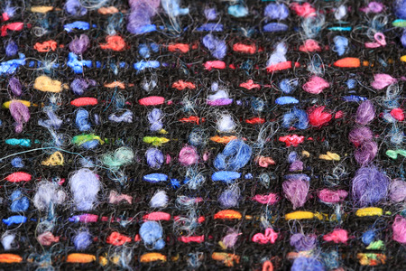 macro texture wool black fabric with colored speckles studio