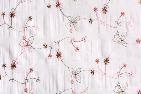 macro texture of white fabric with floral embroidery studio