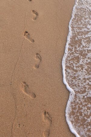 close-up of human footprints in the wet sand at the seasideの写真素材