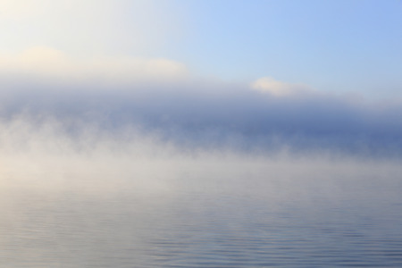 winter landscape dense fog over the river early in the morning at sunrise