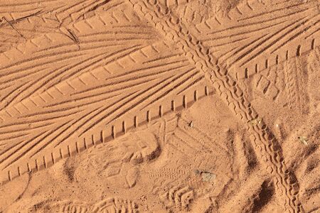 isolated close-up variety of footprints in the sand in sunlightの写真素材