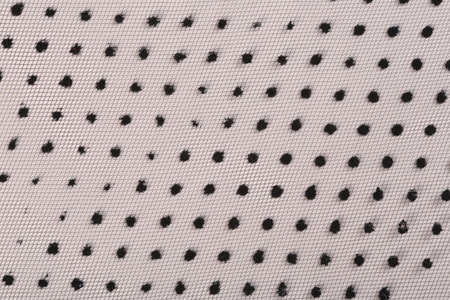 macro texture guipure with black dots on a white background